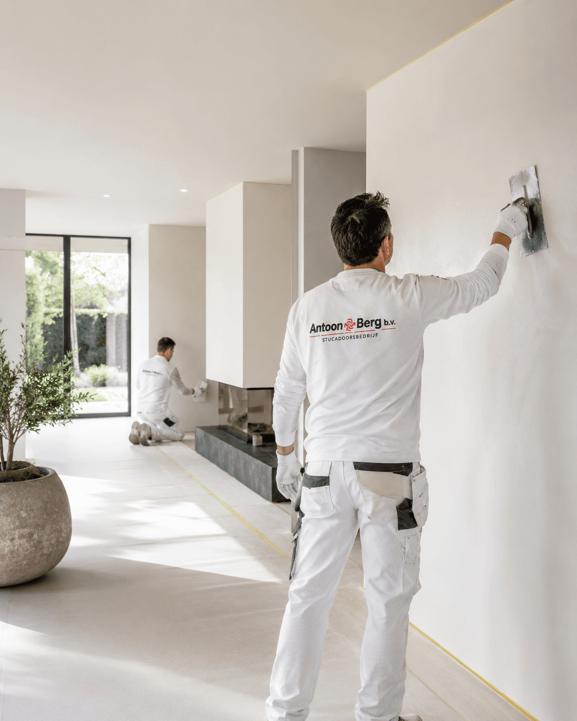 Vakman aan het werk met stucwerk en schilderwerk bij een woning in Breda